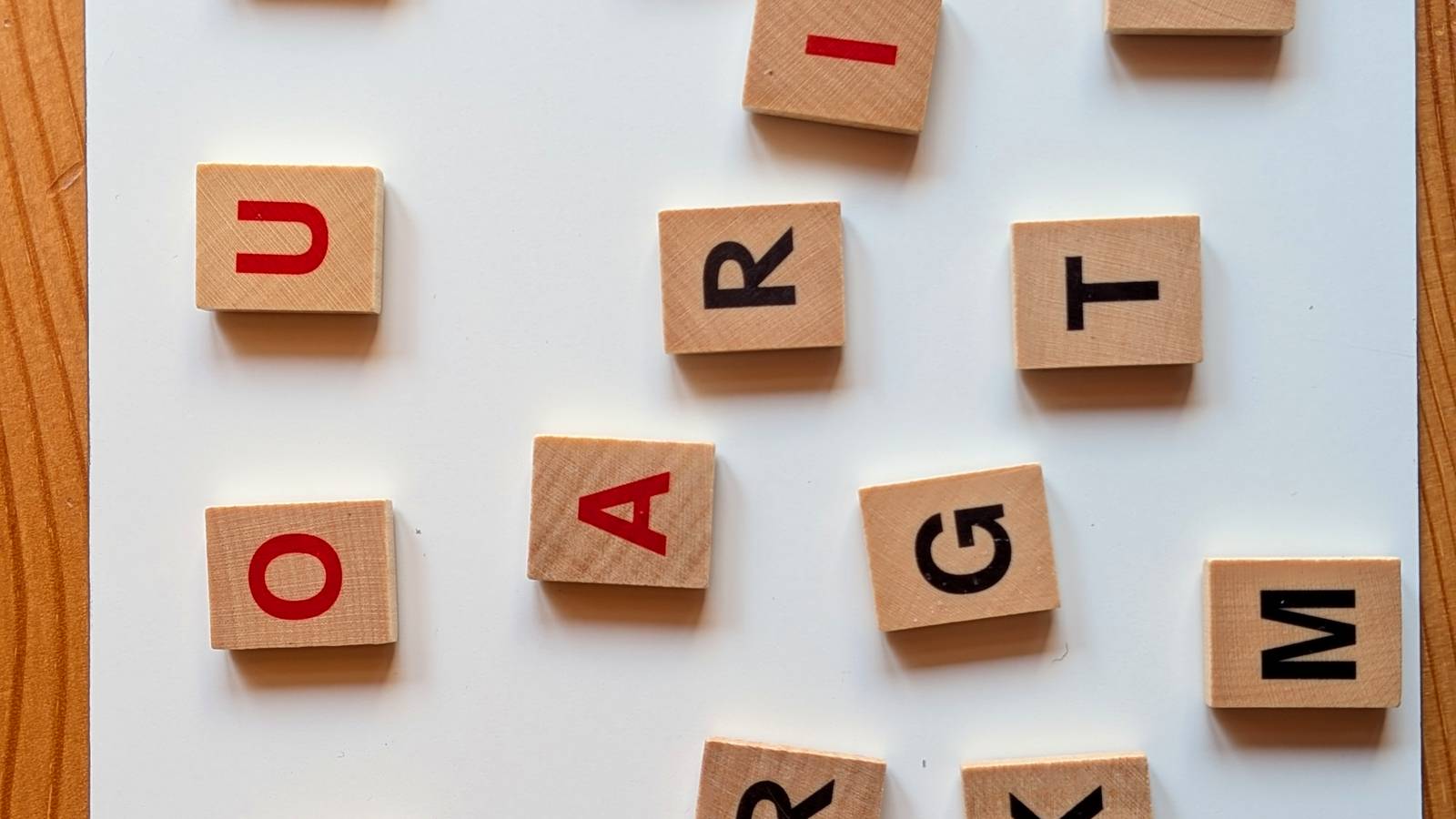 Buchstabenwürfel liegen kreuz und quer auf einer weißen Tafel